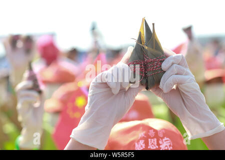 Les touristes et les étudiants prennent des Zongzi, une sorte de gros des boulettes de riz, pour les prochains Dragon Boat Festival, ou Duanwu, à l'espace scénique de la Qu Yu Banque D'Images