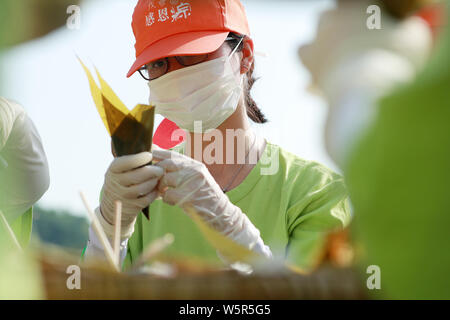 Les touristes et les étudiants prennent des Zongzi, une sorte de gros des boulettes de riz, pour les prochains Dragon Boat Festival, ou Duanwu, à l'espace scénique de la Qu Yu Banque D'Images