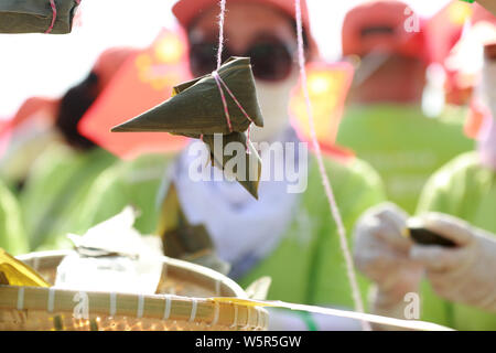 Les touristes et les étudiants prennent des Zongzi, une sorte de gros des boulettes de riz, pour les prochains Dragon Boat Festival, ou Duanwu, à l'espace scénique de la Qu Yu Banque D'Images