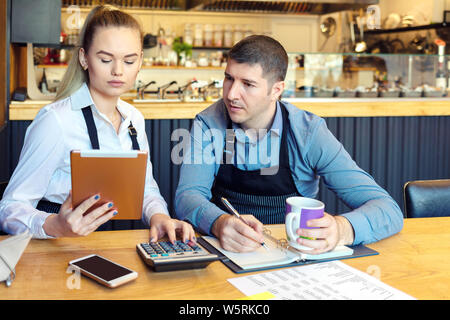 Petit restaurant familial propriétaire discuter finances calcul de projets et dépenses de petite entreprise Banque D'Images