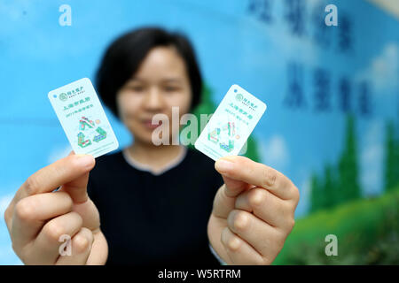 Les résidents locaux montre les cartes QR code utilisé pour ouvrir différents bacs pour mettre leurs déchets à un point de collecte des déchets à Shanghai, Chine, le 19 juin 2019. S Banque D'Images