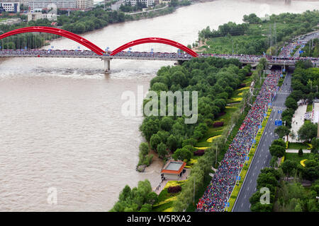 Les participants courent à partir de la ligne de départ le long d'une rivière au cours de la 2019 Lanzhou Marathon International de la ville de Lanzhou, province de Gansu, du nord-ouest de la Chine Banque D'Images