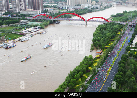 Les participants courent à partir de la ligne de départ le long d'une rivière au cours de la 2019 Lanzhou Marathon International de la ville de Lanzhou, province de Gansu, du nord-ouest de la Chine Banque D'Images