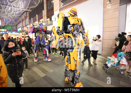 Un étudiant portant un deux mètres de haut réplique grandeur de Bumblebee est entouré par les clients à un centre commercial dans la ville de Xi'an, dans le nord-ouest de la Chine Banque D'Images