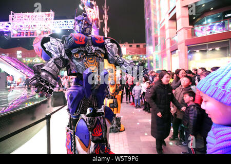 Un étudiant portant un deux mètres de haut réplique grandeur de Megatron est entouré par les clients à un centre commercial dans la ville de Xi'an, dans le nord-ouest de la Chine" Banque D'Images