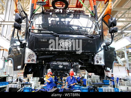 --FILE--travailleurs chinois assembler des camions lourds de Jiefang sur la chaîne de montage dans une usine de FAO dans la ville de Qingdao, province du Shandong en Chine de l'Est, 29 Se Banque D'Images
