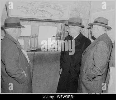 Photographie du président Truman et le secrétaire de l'intérieur Harold Ickes, avec d'autres, regarder par la fenêtre de l'intérieur du Monument de Washington. Banque D'Images