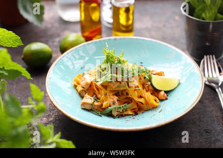 Tagliatelles au saumon grillé dans une sauce à la crème avec l'ajout de vin blanc Banque D'Images