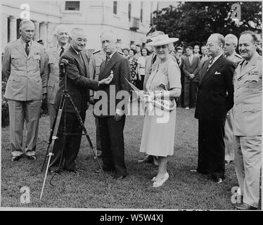 Photographie du président Truman l'attribution de la Médaille du service distingué au secrétaire d'État James Byrnes dans la roseraie de la Maison Blanche : (de gauche à droite) le Général George C. Marshall ; le Général Henry Hap Arnold ; le président ; Secrétaire Byrnes ; sa femme, Maude Byrnes ; John Snyder, du Bureau de mobilisation de guerre et la reconversion ; et le général Harry Vaughan, le président de l'aide militaire. Banque D'Images