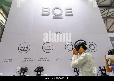 --FILE--un visiteur essaie l'appareil VR au stand de BOE Technology lors d'une exposition à Shanghai, Chine, 27 juin 2018. Panneau d'écran chinois ma Banque D'Images