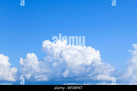 Ciel bleu avec des nuages cumulus massive sur horizon à jour. La texture naturelle de fond photo Banque D'Images