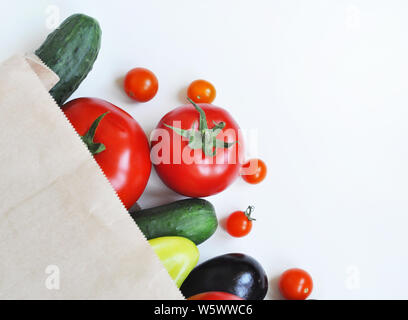 Sac en papier avec des concombres, tomates, aubergines et poivrons. Eco Shopping concept, produits de cuisson. Vue de dessus avec l'espace pour le texte. Banque D'Images