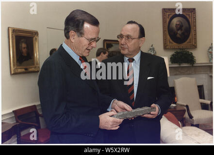 Le président Bush est présenté avec un morceau du Mur de Berlin par l'Ouest Le ministre allemand des affaires étrangères, Hans-Dietrich Genscher dans le bureau ovale Banque D'Images