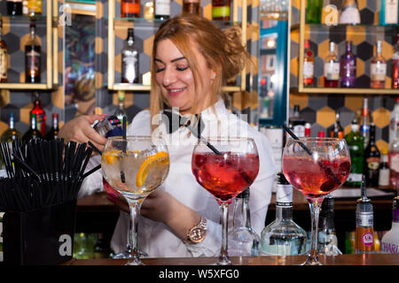 Doncaster, Royaume-Uni - 11 mai 2019 : A smiling waitress mélange des cocktails colorés derrière le bar à à La Boca restaurant & Steakhouse, Netherhall Road 1 Banque D'Images