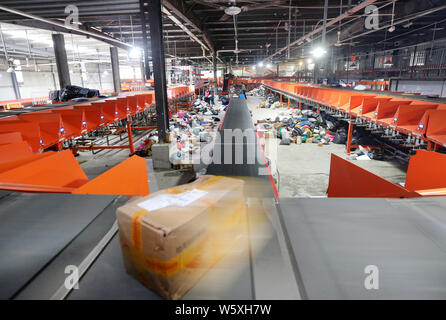 Les travailleurs chinois trier les colis, dont la plupart sont des célibataires de jour des achats en ligne, à un centre de distribution d'une société au cours de la Novem Banque D'Images