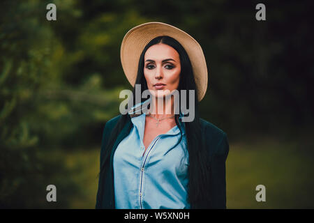 Tom Sawyer jolie femme dans le faisceau de la hat standing en face de clôture. La femme a peint une clôture en bois. Banque D'Images