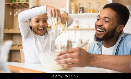 Afro girl ludique s'amusant avec la pâte pendant la cuisson Banque D'Images