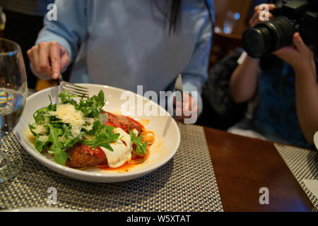 Délicieux poulet parmigiana garnir de fromage et roquette prêt à être consommés comme aliments photographe prend fin. Banque D'Images