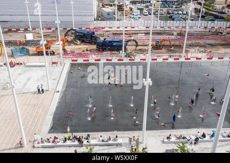 Le nouveau dispositif de l'eau miroir et fontaines de Centenary Square, Birmingham avec la nouvelle extension de métro en construction à l'arrière-plan Banque D'Images