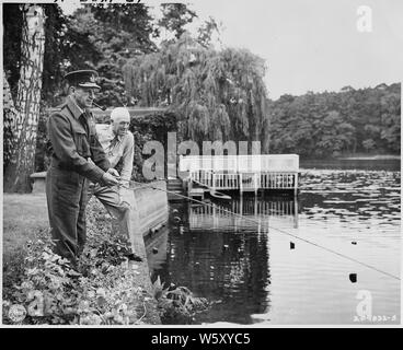 Sir Charles Portal (tenant la canne à pêche), Maréchal de la Royal Air Force, et le Général Henry Hap Arnold, général commandant, U.S. Army Air Forces, pêchent le long d'un lac bordé de fleurs dans la zone de conférence de Potsdam à Potsdam, en Allemagne. Ces hommes ont été responsables de l'énorme offensive aérienne contre l'Allemagne et de Berlin en particulier. Banque D'Images