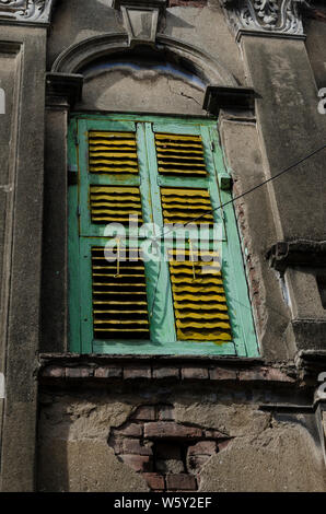 Fenêtre traditionnelle sur l'ancien mur de béton endommagé Banque D'Images