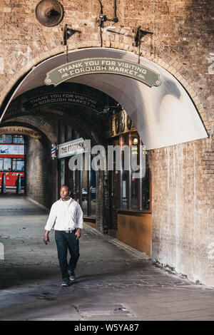 Londres, Royaume-Uni - 23 juillet 2019 : man walking sous 'Merci de visiter' signe au-dessus de la sortie de Borough Market, l'une des plus grandes et des plus anciennes food mar Banque D'Images