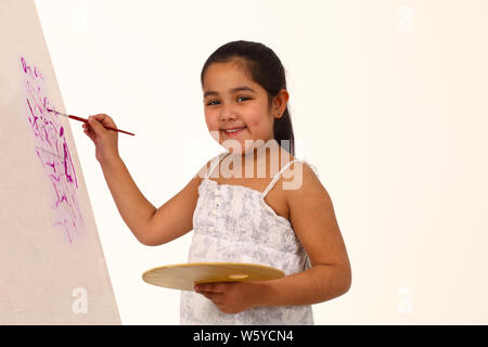 Girl painting on easel et souriant Banque D'Images