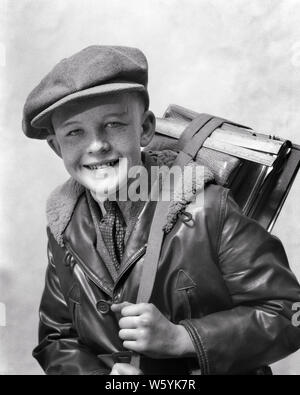 Années 1920 Années 1930 SMILING PRETEEN BOY WEARING CAP GAVROCHE LAINE BLOUSON EN CUIR CRAVATE LOOKING AT CAMERA HOLDING BOOK - b10161 HAR001 HARS, ÉQUILIBRE DU VISAGE HEUREUX JOIE SATISFACTION STYLE STUDIO SHOT SANTÉ États-unis demi-longueur de laine INSPIRATION TISSU États-unis D'AMÉRIQUE SPIRITUALITÉ ROUSSEUR MÂLES EXPRESSIONS CONFIANCE B&W EYE CONTACT ÉCOLES OBJECTIFS RÊVES SUCCÈS BONHEUR E ANNÉE JOYEUSE LUMINEUSE CHOIX COURAGE FORCE INTELLIGENTE DIRECTION D'EXCITATION CONNAISSANCES FIERTÉ CRAVATE PRETEEN SHARP PRIMAIRE IMAGINATION CONCEPTUELLE DES SOURIRES JOYEUX CRIEUR ÉLÉGANT K-12 Désireux d'agression Banque D'Images