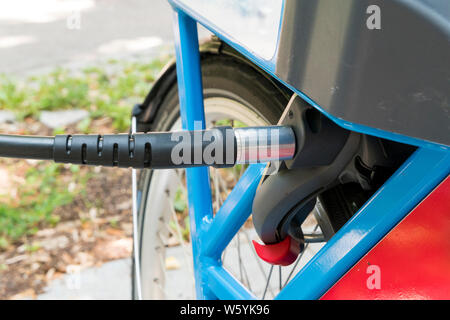 La charge d'un vélo électrique à une station de charge en ville Banque D'Images