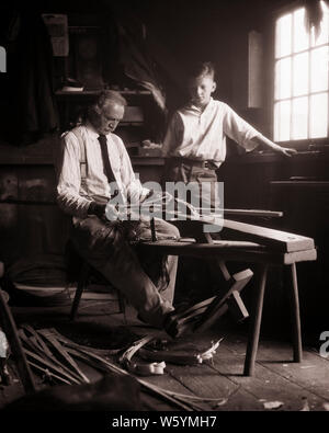 1930 garçon regardant artisan façonner un vieux bâton de crosse en bois de l'École gère l'aide DRAWKNIFE TOUT EN RESTANT ASSIS SUR LE RASAGE HORSE - c4523 HAR001 STICK HARS NOSTALGIE occupé l'ancienne industrie 1 GRAND-PÈRE FILS DE RASAGE POUR MINEURS CÉLÉBRATION DE L'HISTOIRE DE VIE D'UN GRAND-PARENT COPIE ESPACE RURAL EMPLOI pleine longueur d'amitié de l'INSPIRATION POUR LES PERSONNES DE CONFIANCE LES HOMMES D'ÂGE MOYEN DES PÈRES B&W HOMME D'ÂGE MOYEN DE L'OCCUPATION DE COMPÉTENCES COMPÉTENCES BONHEUR SERVICE CLIENT CONNAISSANCES PAPAS UNE OCCASION DE FIERTÉ SUR L'autorité à l'AIDE D'UN PETIT-ENFANT COMBINAISON PROFESSIONS VICE CONCEPTUEL poignée bois élégant petit-fils Workbench Banque D'Images