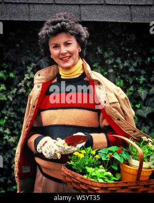 1980 SMILING WOMAN WEARING SWEATER JACKET YELLOW ROULES GARDENING GLOVES HOLDING BASKET DE PLANTATIONS LOOKING AT CAMERA - kg9946 PHT001 HARS HEUREUX JOIE SATISFACTION DE VIE RURALE VIE FEMELLES ACCUEIL ESPACE COPIE MESDAMES MI-LONGUEUR DE LA CONFIANCE DES PERSONNES DE CONTACT AVEC LES YEUX D'ÂGE MOYEN DE L'ACTIVITÉ COMPÉTENCE BRUNETTE AMUSEMENT BONHEUR middle-aged WOMAN CHEERFUL HOBBY STYLES LOISIRS HOBBIES INTÉRÊT PASSE-TEMPS CONNAISSANCES FIERTÉ PLAISIR SOURIRE Travaux extérieurs haut de gamme élégant joyeuse de l'HORTICULTURE AU DÉBUT DU PRINTEMPS DE LA MODE CHIC PRINTEMPS RELAXATION ETHNICITÉ CAUCASIEN AMATEUR JOUISSANCE OLD FASHIONED ROULES PLANTATIONS Banque D'Images