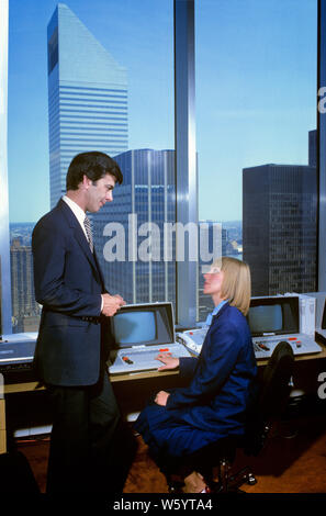 Années 1980 AVEC DU MATÉRIEL DE BUREAU URBAIN DÉBUT FEMME ASSIS À L'ORDINATEUR PAR FENÊTRE DE PARLER À l'homme debout à côté d'ELLE - ko1311 PHT001 HARS 1 COMMUNICATION À L'ancienne technologie de l'information ÉQUIPE BLONDE HISTOIRE DE VIE FEMMES COMMUNIQUER ASSIS UNITED STATES COPIE ESPACE PLEIN D'AMITIÉ mi-longueur longueur CHERS PERSONNES ORDINATEURS UNITED STATES OF AMERICA CONFIANCE MÂLES MENU SUIVANT, BUSINESSWOMAN AMÉRIQUE DU NORD NORTH AMERICAN costume et cravate VENDRE HIGH ANGLE DÉBUT NETWORKING SUIT LES PROGRÈS DE L'INNOVATION POUVOIR OCCASION PROFESSIONS NYC HIGH TECH MATÉRIEL CONNEXION APPAREIL ÉLECTRIQUE Banque D'Images