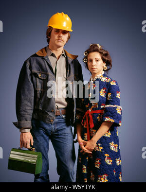 1970 of Asian American GOTHIC MAN IN HARD HAT DENIM PRÊT POUR TRAVAILLER DANS LES ROULEAUX DE FEMME PORTANT DES CHEVEUX ROBE LOOKING AT CAMERA - ks12292 HAR001 NOSTALGIE HARS 1 OLD FASHION STYLE BANDE DESSINÉE idiote d'ÉQUIPE DE SÉCURITÉ DE VIE FEMMES COTON PRÊT STUDIO SHOT MARIÉS MARI CONJOINT RURAL HOME LIFE COPIE Espace demi-longueur d'amitié chers hommes PERSONNES AMERICANA DENIM MATIN TRISTESSE PARTENAIRES CONTACT VISUEL ROULEAUX BIGOUDIS MÉNAGÈRE COL BLEU AU FOYER avec humour l'EMPLOI DU TRAVAIL COMIQUE MANUEL PROFESSIONS MÉNAGÈRES COMÉDIE CONCEPTUELLE CONNEXION EMPLOYÉ DE LA CLASSE MOYENNE LES BLUE-JEANS ROBE DE COOPÉRATION Banque D'Images