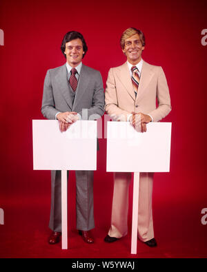 1970 DEUX SMILING BUSINESSMEN VENDEURS portant des costumes à la caméra à chaque port d'une plaque-étiquette DE SIGNER LE MESSAGE EN BLANC - ks15092 HAR001 HARS CONVIENT À PROTESTER CONTRE LA SATISFACTION DE VIE HEUREUX JOIE CÉLÉBRATION STUDIO SHOT GROWNUP COMMUNICATION MANAGER COPIE ESPACE l'amitié des personnes demi-longueur grown-up HISTOIRE DE CŒUR DES CADRES DE CONFIANCE CONTACT OCULAIRE EN COL BLANC OBJECTIFS costume cravate VENTE OCCUPATION FORCE JOYEUX BONHEUR STRATEGY LEADERSHIP FIERTÉ UNE AUTORITÉ POLITIQUE PROFESSIONS OCCASION Patrons de sourires JOYEUX CONCEPTUEL CONNEXION GESTIONNAIRES COOPÉRATION COMMUNIQUER ÉLÉGANT Banque D'Images