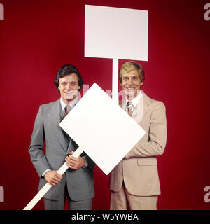 1970 DEUX SMILING BUSINESSMEN VENDEURS portant des costumes à la caméra à chaque port d'une plaque-étiquette DE SIGNER LE MESSAGE EN BLANC - ks15096 HAR001 HARS CONVIENT À PROTESTER CONTRE LA SATISFACTION DE VIE HEUREUX JOIE CÉLÉBRATION STUDIO SHOT GROWNUP COMMUNICATION MANAGER COPIE ESPACE l'amitié des personnes demi-longueur grown-up HISTOIRE DE CŒUR DES CADRES DE CONFIANCE CONTACT OCULAIRE EN COL BLANC OBJECTIFS costume cravate VENTE OCCUPATION FORCE JOYEUX BONHEUR STRATEGY LEADERSHIP FIERTÉ UNE AUTORITÉ POLITIQUE PROFESSIONS OCCASION Patrons de sourires JOYEUX CONCEPTUEL CONNEXION GESTIONNAIRES COOPÉRATION COMMUNIQUER ÉLÉGANT Banque D'Images