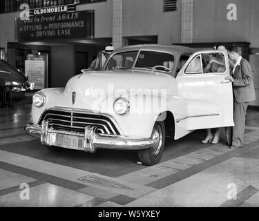 1940 COUPLE NOUVELLE VOITURE MODÈLE 1946 À 1950 concessionnaire automobile à 1730 BROADWAY NEW YORK - q45318 CPC001 SHOWROOM HARS FEMELLES VIE DÉCISION MARIÉS MARI CONJOINT LUXURY UNITED STATES COPIE ESPACE CHERS PERSONNES concessionnaire automobile des États-Unis d'Amérique HOMMES TRANSPORT CONCESSIONNAIRE B&W OBJECTIFS CLIENT PARTENAIRE SERVICE CLIENTÈLE SHOPPERS TENTATION AUTOS OLDSMOBILE OCCASION INNOVATION PROGRÈS CHOIX CONCEPTUEL ACHAT NYC NEW YORK 1946 Véhicules automobiles élégantes villes NEW YORK CITY NOUVELLE VOITURE COOPÉRATION BROADWAY FEMME NOIR ET BLANC à l'ANCIENNE Origine ethnique Caucasienne Banque D'Images