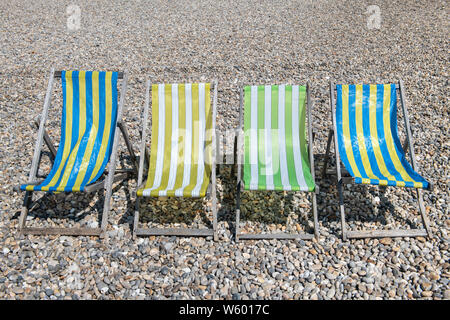 Quatre transats vides s'asseoir sur la plage de la bière au milieu de l'été. Banque D'Images