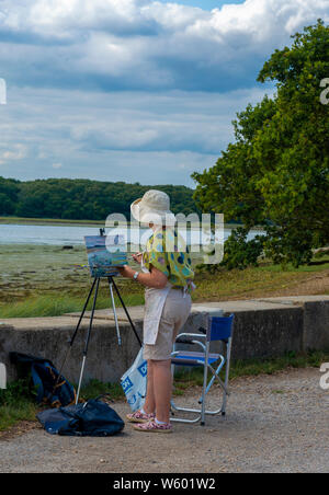 La peinture de l'artiste féminine la scène dans Chichester Harbour, Chichester, West Sussex, Angleterre, Royaume-Uni Banque D'Images