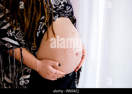 Art dessin floral henné inoffensifs sur boho femme enceinte ventre, le beau concept de la maternité. La lumière blanche de l'espace de copie. Banque D'Images