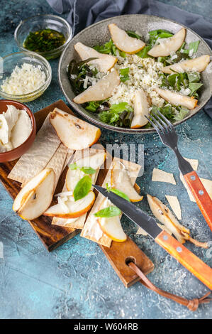 Régime céto. Salade avec du fromage cottage, Romano, feuilles de poires douces et de fromage. Des biscuits au fromage à la crème avec des tranches de poire. Shot verticale Banque D'Images