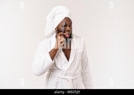 Portrait of a happy young dark-anm se brosser les dents avec du dentifrice noir sur fond blanc Banque D'Images