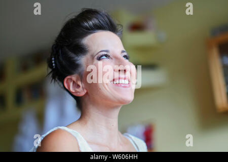 Matin de la mariée avant le mariage. Processus d'artiste de maquillage est terminé. Mariée est heureux et en attente pour le marié. Banque D'Images