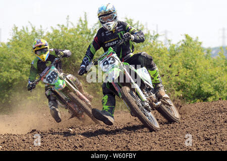 Les motards sur des vélos de course, scramble boueux sur piste de course. Le motocross est une forme de course de moto qui a eu lieu sur les circuits tout-terrain clos. Banque D'Images