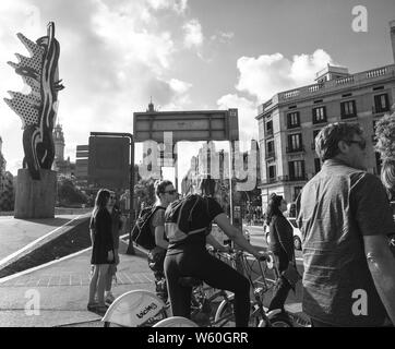 Barcelone, Espagne - 1 juin 2018 : Les piétons les cyclistes hommes et femmes en attente de franchir le pas de la rue animée Sota Muralla au coucher du soleil - noir et blanc Banque D'Images