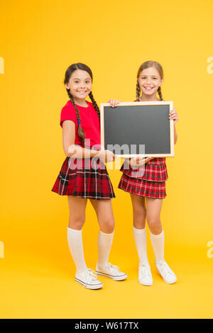 Cours de Cheerleading. School girls cute pupils uniforme rouge tenir copie tableau noir l'espace. Annonce école concept. Équipe de l'initiative de camarades. Inscrivez-vous le club scolaire. Les élèves de la communauté. L'annexe de l'école. Banque D'Images