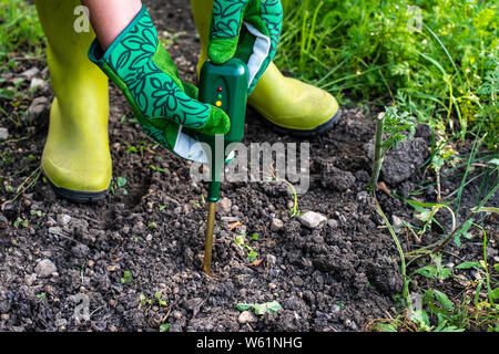 Sol nutriments mètre. Mesurer la teneur en azote du sol avec dispositif numérique. Agricultrice dans un jardin. Concept pour la nouvelle technologie dans l'agriculture. Banque D'Images