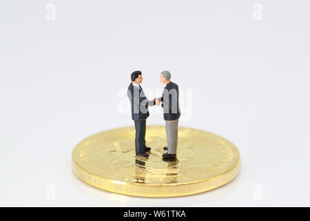 Les gens miniature : un groupe de businessman standing on bitcoin (cette image pour la concurrence commerciale et financière concept) Banque D'Images