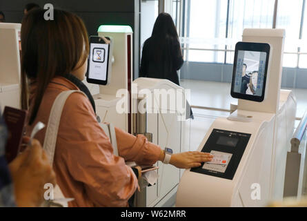 Un passager scanne sa carte d'embarquement sur un libre-service machine équipée de fonctions de reconnaissance faciale au terminal T1 Ho de Shanghai Banque D'Images