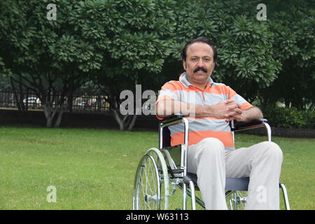 Homme assis dans un fauteuil roulant Banque D'Images