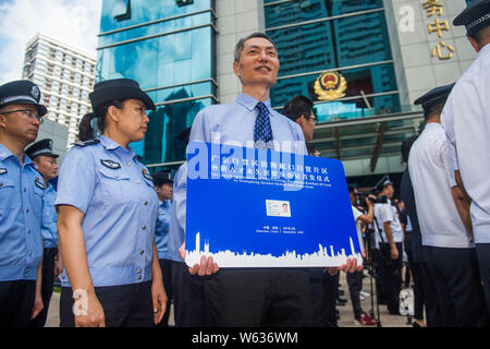 - L'homme Zhang Wei montre sa carte d'identité de résident permanent étranger délivré par le Guangdong Qianhai Shekou Zone de libre-échange lors du lancement Banque D'Images